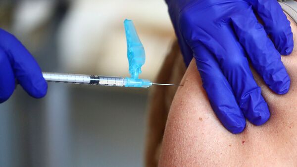A health worker receives an injection with a dose of the Pfizer-BioNTech COVID-19 vaccine, amid the coronavirus disease (COVID-19) outbreak, at Fuentelarreina primary healthcare centre in Madrid, Spain, 18 January 2021. - Sputnik International
