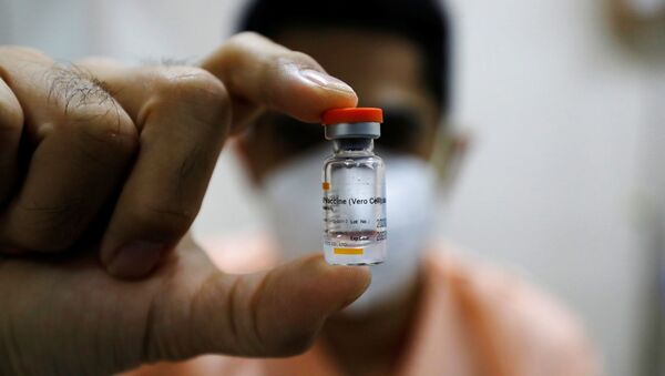 An Indonesian doctor shows a bottle of the Sinovac vaccine before receiving a dose of it at a hospital in Jakarta - Sputnik International