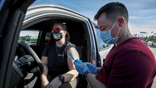 Dr. Richard Dang, assistant professor USC School of Pharmacy administers COVID-19 vaccine to Ashley Van Dyke (L) as mass-vaccination of healthcare workers takes place at Dodger Stadium in Los Angeles, California, U.S., January 15, 2021 - Sputnik International