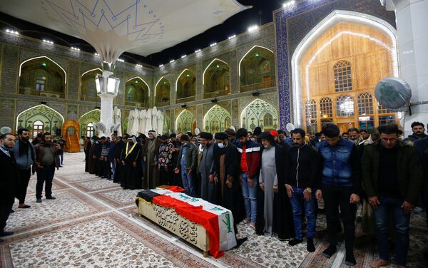 Mourners gather near the coffin of a man, who was killed in a twin suicide bombing attack in a central Baghdad market, during a funeral in Najaf, Iraq, January 21, 2021. - Sputnik International