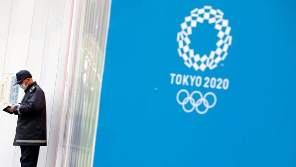 A security officer stands next to the Tokyo 2020 Olympic Games logo, amid the coronavirus disease (COVID-19) outbreak in Tokyo, Japan December 24, 2020. - Sputnik International