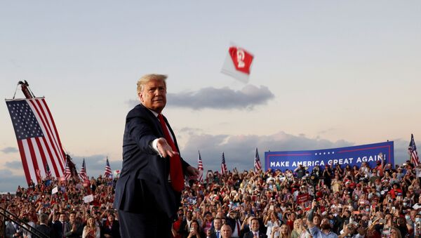 FILE PHOTO: U.S. President Donald Trump throws a face mask from the stage during a campaign rally, his first since being treated for the coronavirus disease (COVID-19), at Orlando Sanford International Airport in Sanford, Florida, U.S., October 12, 2020. - Sputnik International