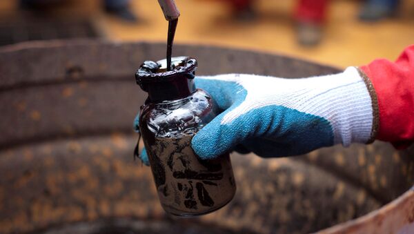 A worker collects a crude oil sample at an oil well operated by Venezuela's state oil company PDVSA in Morichal, Venezuela, 28 July 2011. - Sputnik International