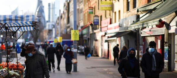 People walk past shops and market stalls, amid the coronavirus disease (COVID-19) outbreak, in east London, Britain, January 23, 2021. - Sputnik International