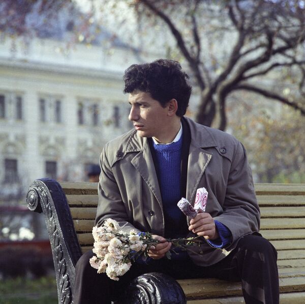 A man waits for his girlfriend, holding a bunch of flowers and two Eskimo pies. Moscow, 1973.  - Sputnik International