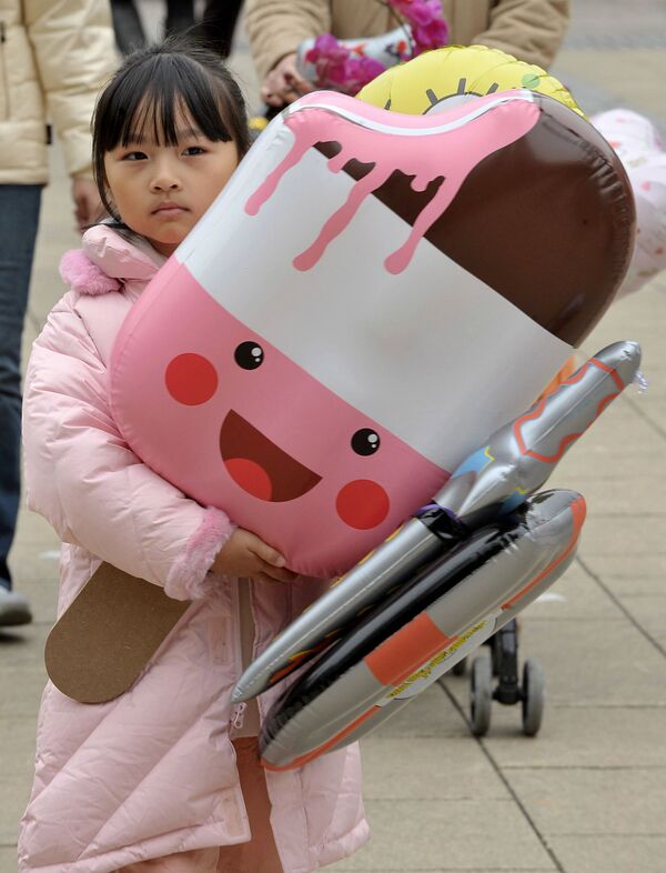 A girl walks home with a giant blow up ice cream at a Chinese New Year fair at a local park in Hong Kong on 4 February, 2008.  - Sputnik International
