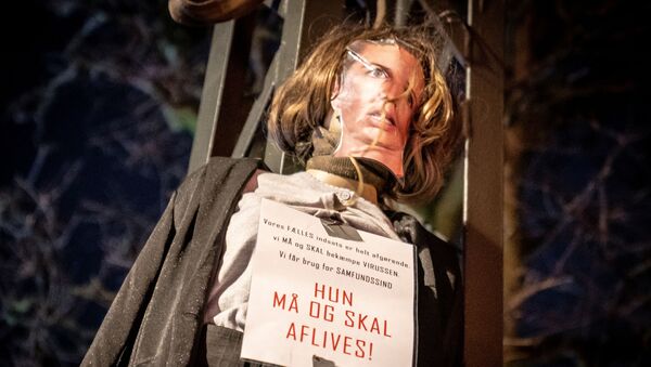 An effigy representing Danish Prime Minister Mette Frederiksen with a sign reading She must be put down hangs on a street during a protest by a group called Men in Black against COVID-19 restrictions in Copenhagen, Denmark  - Sputnik International