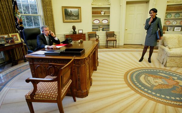 President  Bush, left, speaks with Spanish Prime Minister Jose Maria Aznar by phone from the Oval Office of the White House as National Security Adviser Condoleezza Rice, right, looks on 10 March 2003.  - Sputnik International