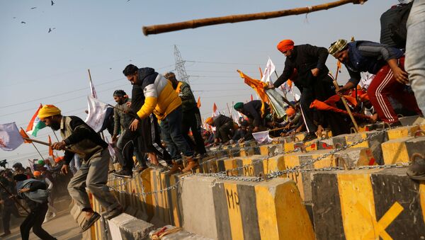 Farmers cross a barricade during a tractor rally to protest against farm laws on the occasion of India's Republic Day in Delhi, India, January 26, 2021 - Sputnik International