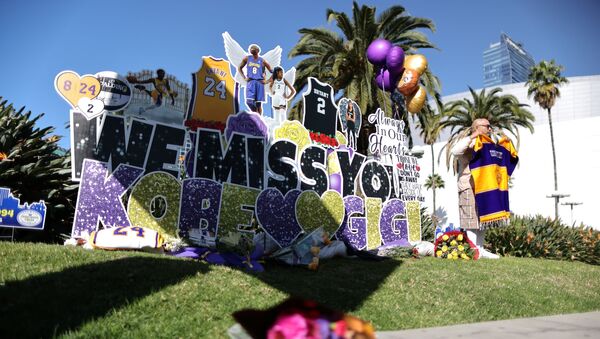 Flowers and pictures are placed as fans gather for a memorial to late Kobe Bryant, who perished one year ago alongside his daughter and seven others when their helicopter crashed into a hillside near Los Angeles, outside the Staples Center in Los Angeles, California, U.S., January 26, 2021 - Sputnik International