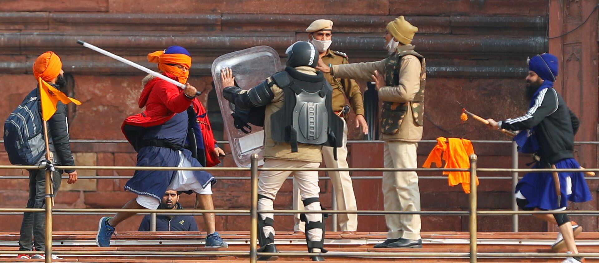 A Nihang (sikh warrior) beats a policeman with a baton during a protest against farm laws introduced by the government, at the historic Red Fort in Delhi, India, January 26, 2021 - Sputnik International, 1920, 09.02.2021
