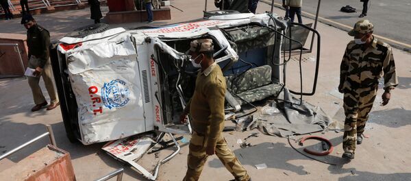 Policemen walk past a damaged police vehicle outside the historic Red Fort after Tuesday's clashes between police and farmers, in the old quarters of Delhi, India, January 27, 2021 - Sputnik International