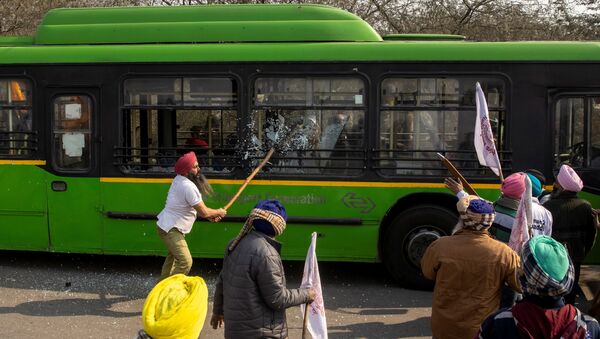 A farmer breaks windows of a government bus as during a tractor rally to protest against farm laws on the occasion of India's Republic Day in New Delhi, India, 26 January 2021. - Sputnik International