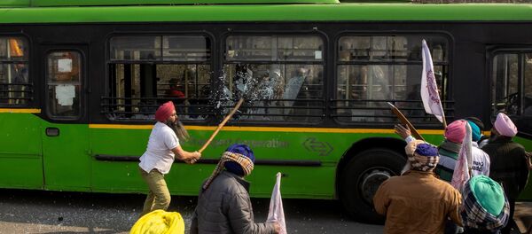A farmer breaks windows of a government bus as during a tractor rally to protest against farm laws on the occasion of India's Republic Day in New Delhi, India, 26 January 2021. - Sputnik International