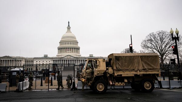 U.S. National Guard troops unload food near barbed wire and security fencing around the U.S. Capitol in Washington, U.S., January 26, 2021. REUTERS/Al Drago - Sputnik International