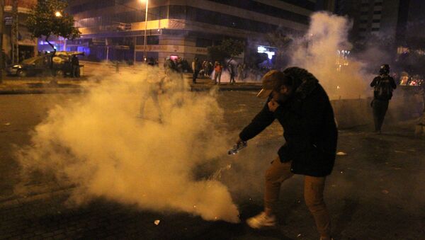 A demonstrator extinguishes a tear gas during a protest against the lockdown and worsening economic conditions, amid the spread of the coronavirus disease (COVID-19), in Tripoli - Sputnik International