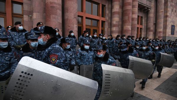 Police officers wear protective face masks during a rally demanding the resignation of Prime Minister Nikol Pashinyan, at Republic Square, in Yerevan, Armenia. - Sputnik International
