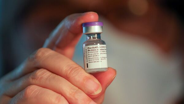 A volunteer and a retired healthcare worker holds a vial of the Pfizer-BioNTech coronavirus disease (COVID-19) vaccine, at Sant Pau hospital, in Barcelona, Spain January 28, 2021. - Sputnik International