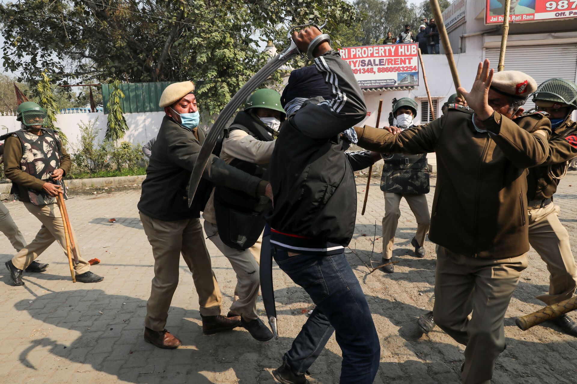 A man wields his sword against a policeman during a clash between protesting farmers and a group of people shouting anti-farmer slogans, at a site of the protest against farm laws at Singhu border near New Delhi, India January 29, 2021. - Sputnik International, 1920, 07.09.2021