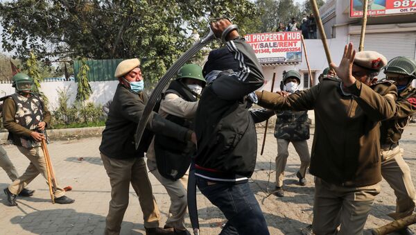 A man wields his sword against a policeman during a clash between protesting farmers and a group of people shouting anti-farmer slogans, at a site of the protest against farm laws at Singhu border near New Delhi, India January 29, 2021. - Sputnik International