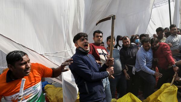 A man, from the group which raised the anti-farmers slogan, shouts as he holds a scythe, at a site of the protest against farm laws at Singhu border near New Delhi, India January 29, 2021. REUTERS/Anushree Fadnavis - Sputnik International