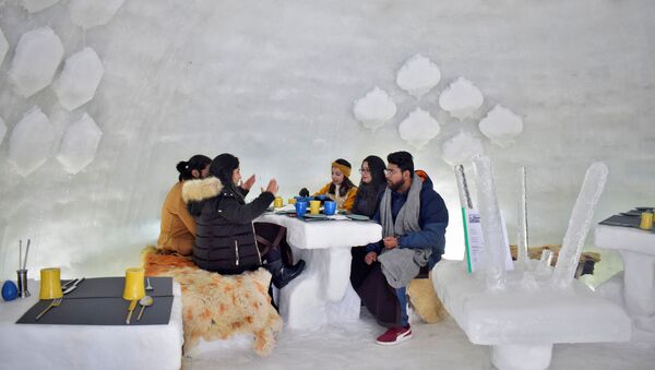 Tourists drink inside Igloo Cafe, a cafe prepared with snow and ice, at Gulmarg, a ski resort and one of the main tourist attractions in Kashmir region, January 28, 2021 - Sputnik International