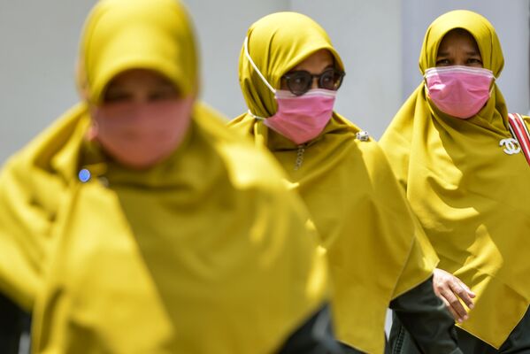 Women wearing hijabs and face masks walk in a public area in Banda Aceh, Indonesia on 2 March 2020.  - Sputnik International