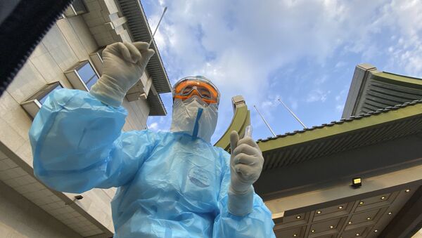 A medical worker prepares to collect a swab sample from a journalist for a COVID-19 test before the National People's Congress closing session and the Chinese premier's press conference in Beijing on 28 May 2020 - Sputnik International