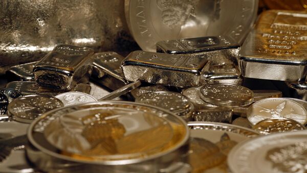 Silver bars and coins are stacked  on a table in the safe deposit boxes room of the ProAurum gold house in Munich, 3 March 2014. - Sputnik International