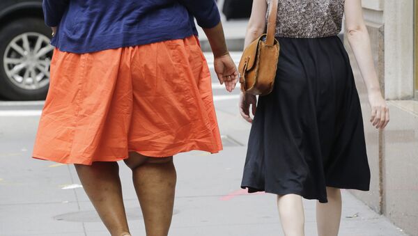 In this Monday, July 13, 2015 photo, an obese woman, left, walks in New York. One-third of American adults and one in six children are now obese, although an annual report released Thursday by two nonprofit groups found that rates could be stabilizing - Sputnik International