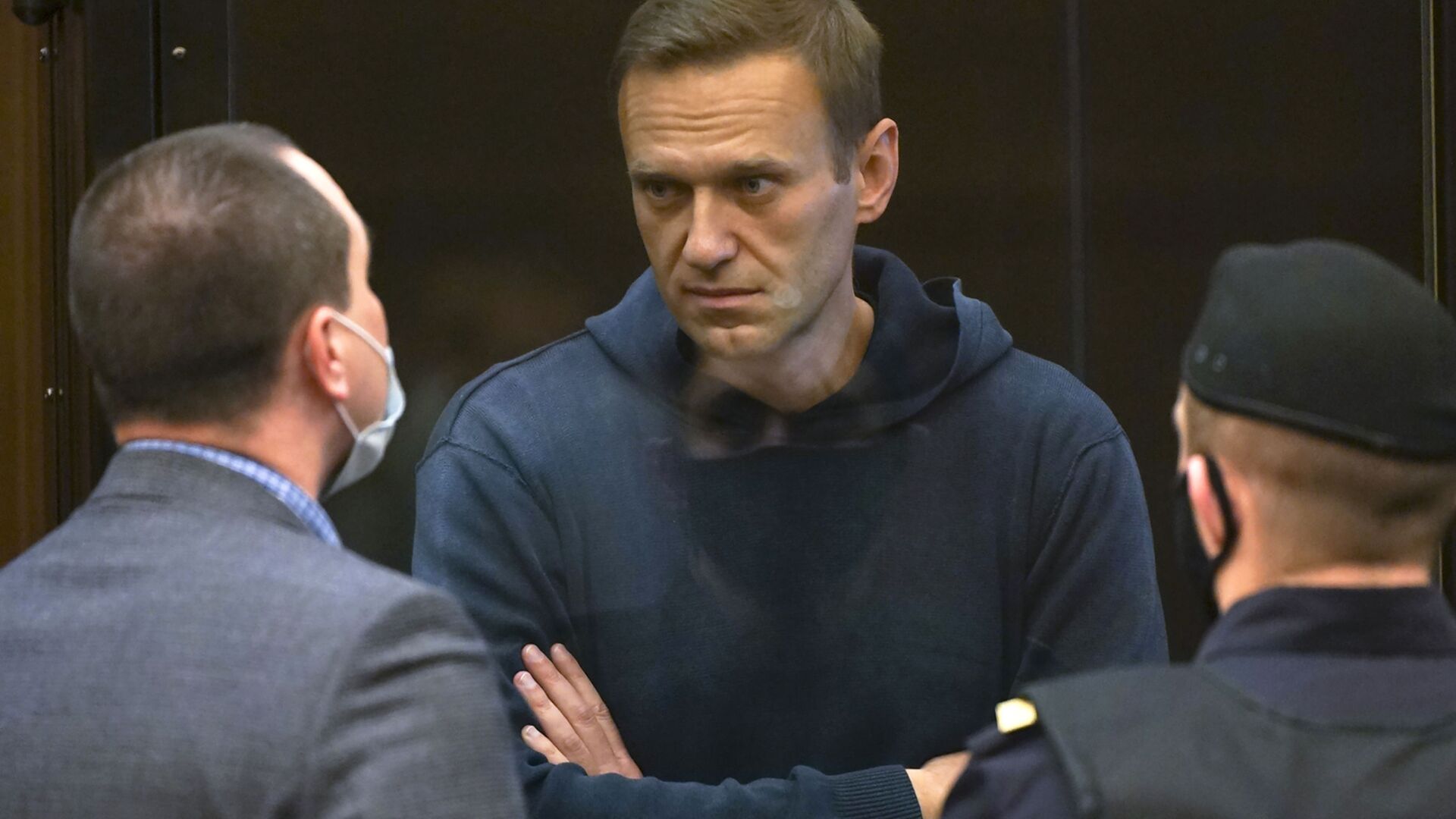 In this handout photo provided by Moscow City Court Russian opposition leader Alexei Navalny talks to one of his lawyers, left, while standing in the cage during a hearing to a motion from the Russian prison service to convert the suspended sentence of Navalny from the 2014 criminal conviction into a real prison term in the Moscow City Court in Moscow, Russia, Tuesday, Feb. 2, 2021. - Sputnik International, 1920, 02.03.2021