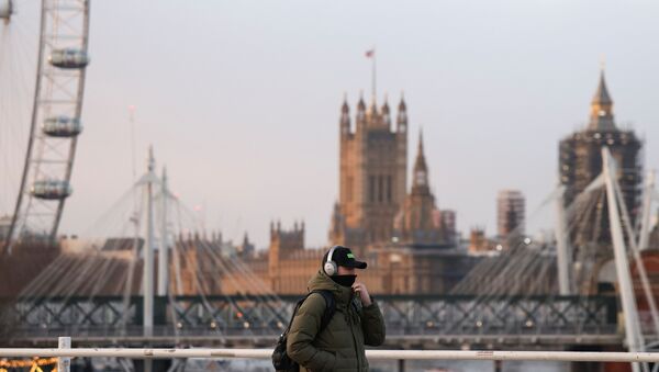 A man wearing a protective face mask walks across Waterloo Bridge, amid the coronavirus disease (COVID-19) outbreak in London, Britain, January 29, 2021. - Sputnik International
