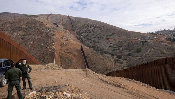 U.S. border patrol agents stand near the location of halted construction along the U.S. Border wall with Mexico as an unfinished  section is shown on Otay Mountain, east of San Diego, California, U.S., February 2, 2021. - Sputnik International
