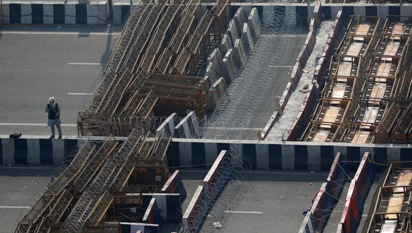 Farmer stands by a barricade at a protest against farm laws at the Delhi-Uttar Pradesh border in Ghaziabad, India  - Sputnik International