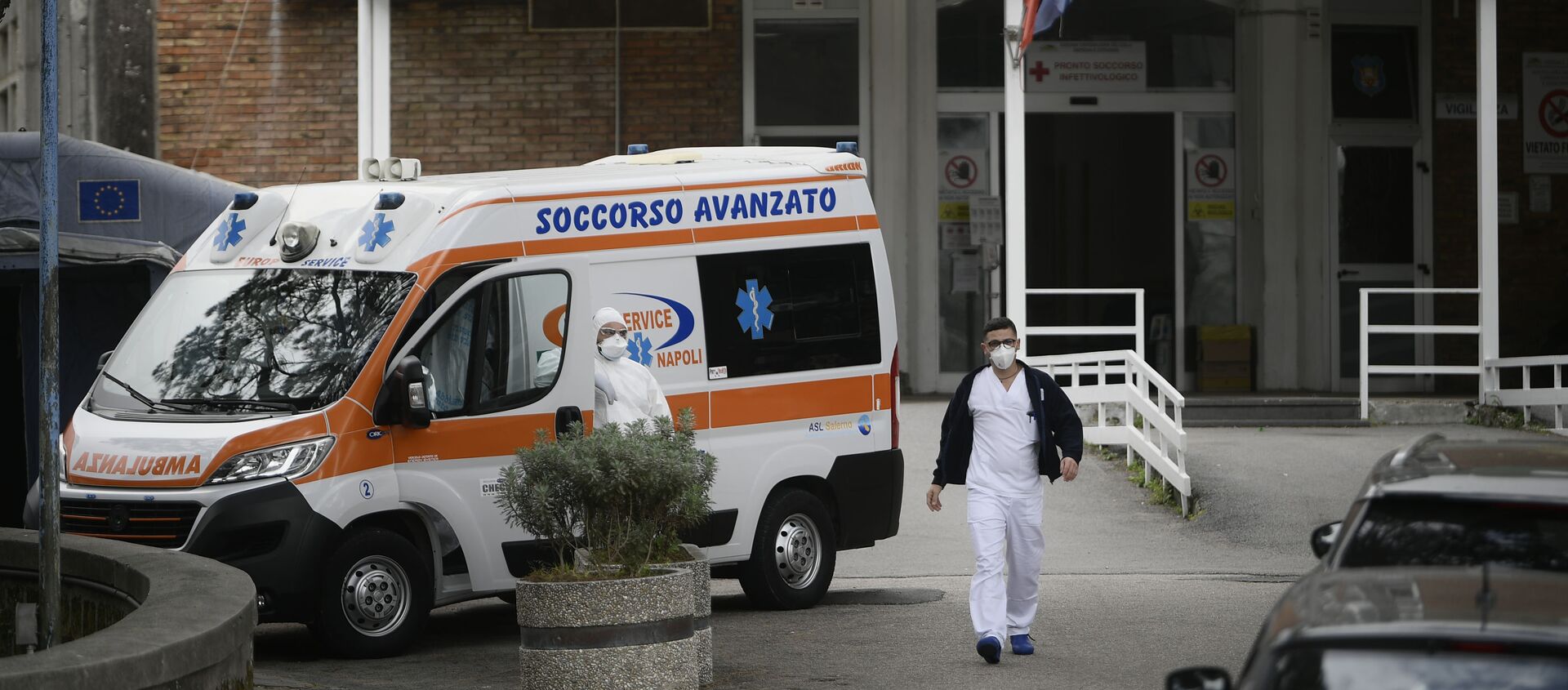 An ambulance is parked outside the entrance to the infectious diseases emergency unit at the Cotugno hospital in Naples on November 12, 2020 amid a surge of COVID-19 cases in Naples overwhelming hospitals. - Sputnik International, 1920, 04.02.2021