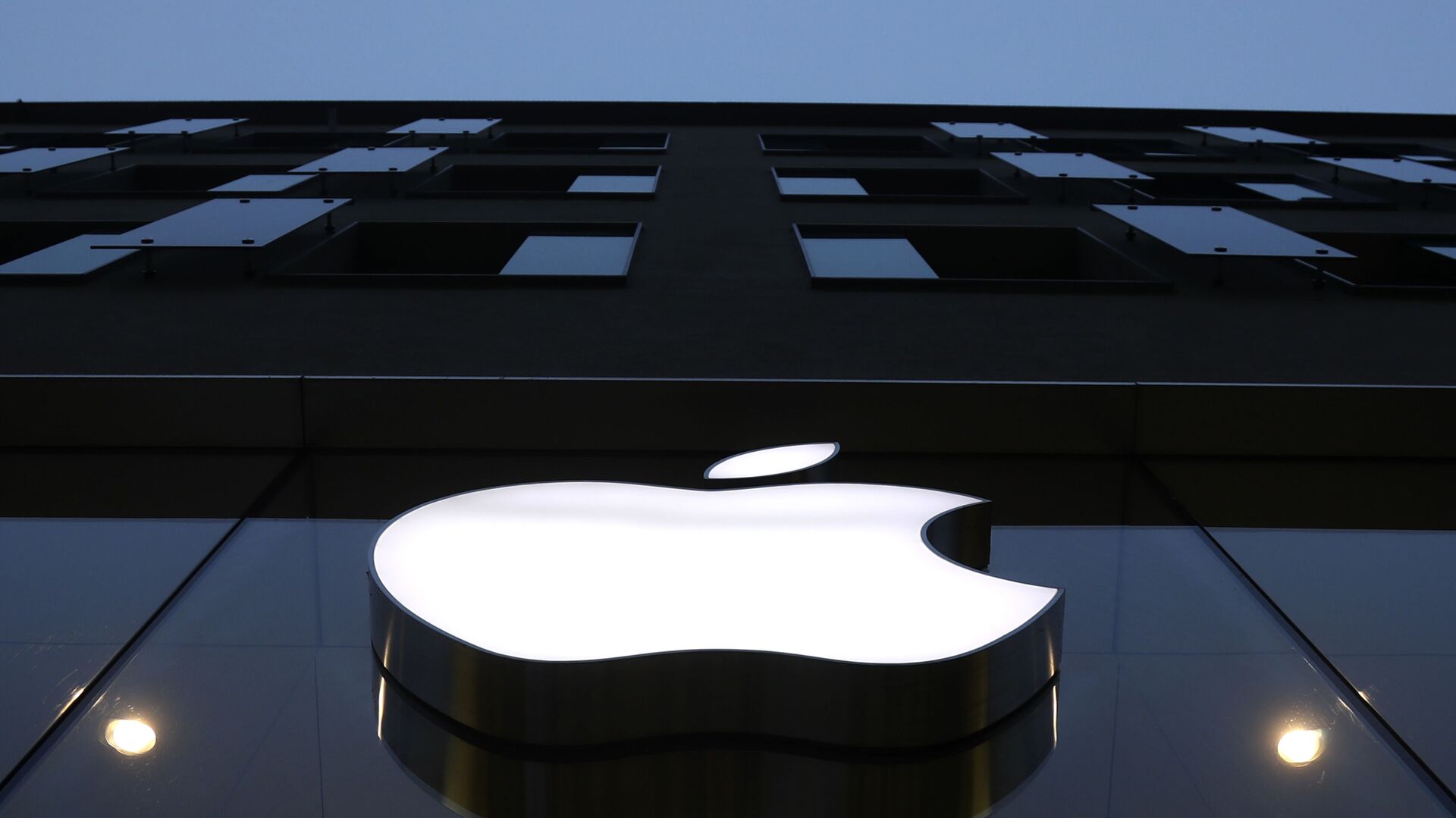 The logo of Apple is illuminated at a store in the city center in Munich, Germany, Wednesday, Dec. 16, 2020. - Sputnik International, 1920, 19.04.2021