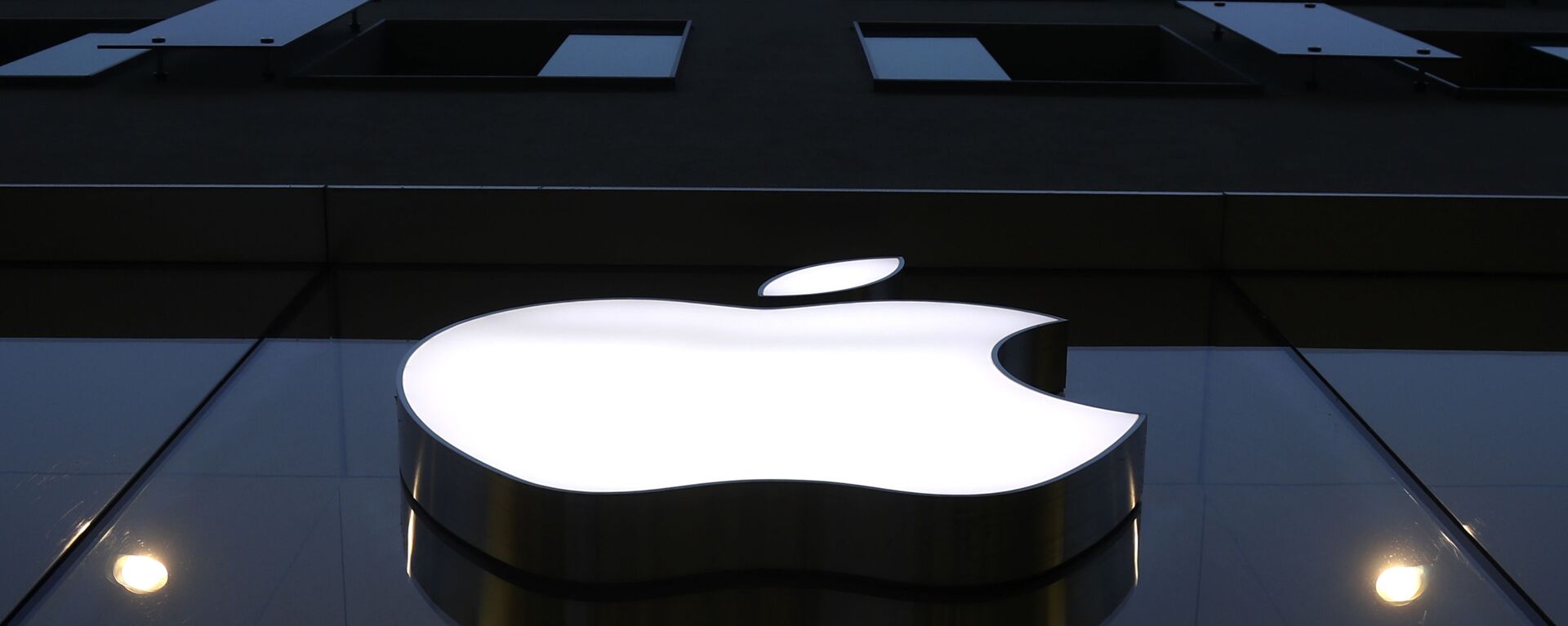 The logo of Apple is illuminated at a store in the city center in Munich, Germany, Wednesday, Dec. 16, 2020. - Sputnik International, 1920, 06.04.2021