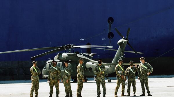 Members of U.S forces stand backdropped by a military helicopter and the U.S. troop carrier Endurance, in the northeast Greek port of Alexandroupolis, near the Turkish border, Thursday, July 23, 2020, where some 2,000 U.S. service members, dozens of helicopters and hundreds of vehicles disembarked - Sputnik International