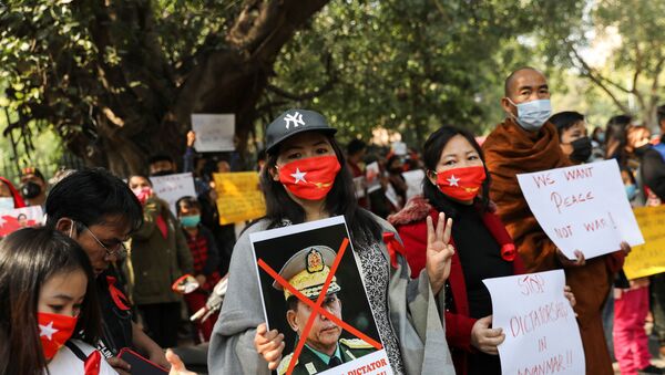 A woman holds a poster of Myanmar's army chief Min Aung Hlaing with his face crossed out during a protest, organised by Chin Refugee Committee, against the military coup in Myanmar, in New Delhi, India, February 5, 2021. REUTERS/Anushree Fadnavis - Sputnik International