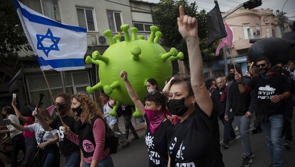 Israeli protesters march with a large inflatable model of the coronavirus during a demonstration against Israeli Prime Minister Benjamin Netanyahu in Tel Aviv, Israel, Friday, Feb. 5, 2021. - Sputnik International