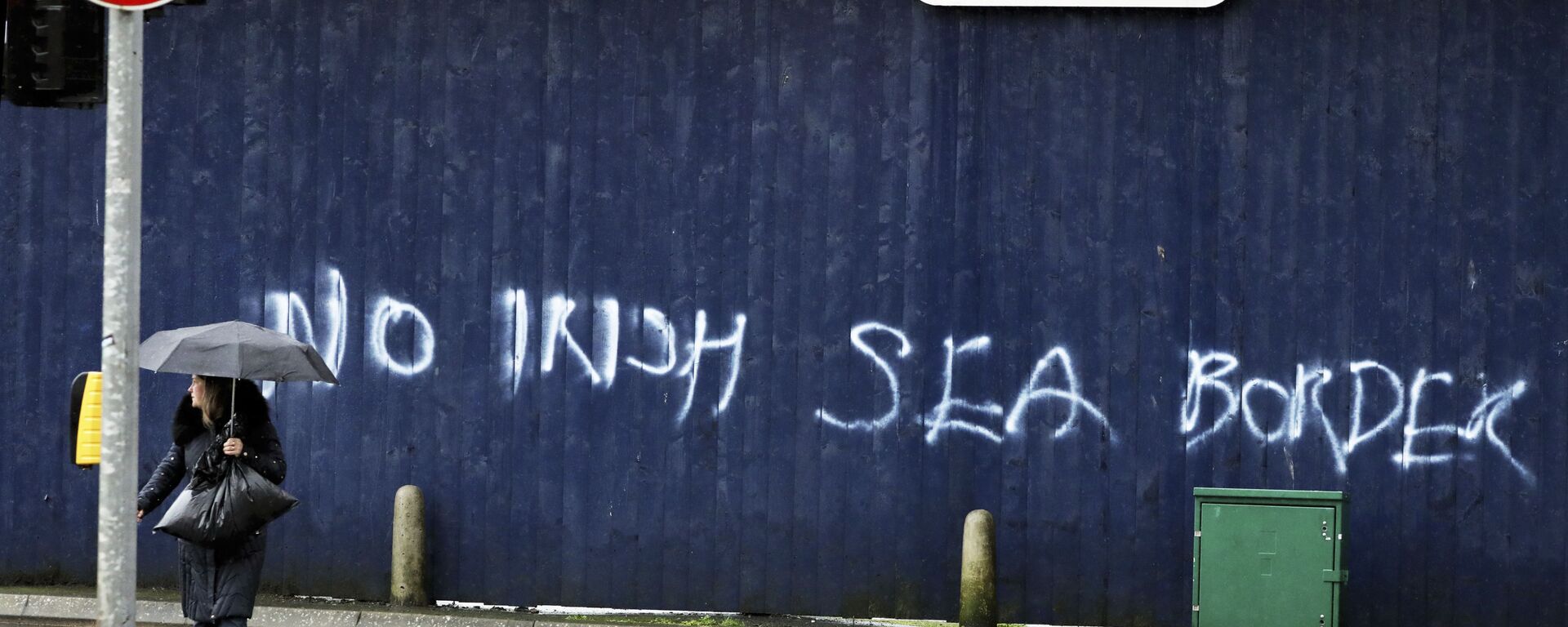 A woman walks past past graffiti with the words 'No Irish Sea Border' in Belfast city centre, Northern Ireland, Wednesday, Feb. 3, 2021 - Sputnik International, 1920, 18.05.2022