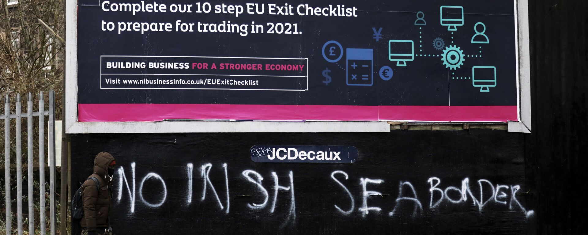 A man walks past graffiti reading No Irish sea border in the mainly loyalist Donegal road area of South Belfast, Northern Ireland, Saturday, Jan. 30, 2021 - Sputnik International, 1920, 21.02.2023