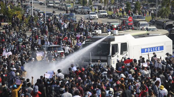 A police truck sprays water to a crowd of protesters in Naypyitaw, Myanmar on Monday, Feb. 8, 2021.  - Sputnik International