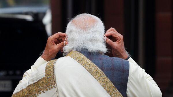India's Prime Minister Narendra Modi adjusts his protective mask after speaking with the media - Sputnik International