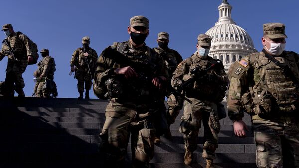 Members of the National Guard walk past the dome of the Capitol Building on Capitol Hill in Washington, Thursday, Jan. 14, 2021 - Sputnik International