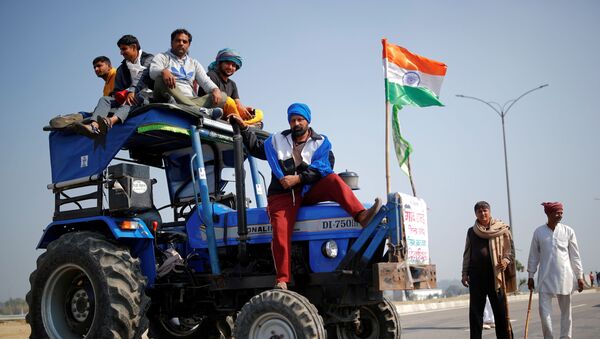 Farmers stand atop a tractor as they take part in a three-hour chakka jam, or road blockade, as part of protests against farm laws on a highway on the outskirts of New Delhi - Sputnik International
