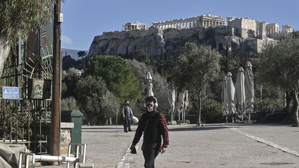 People walk past closed cafes under the Acropolis in central Athens on February 9, 2021, amid the Covid-19 pandemic caused by the novel coronavirus.  - Sputnik International