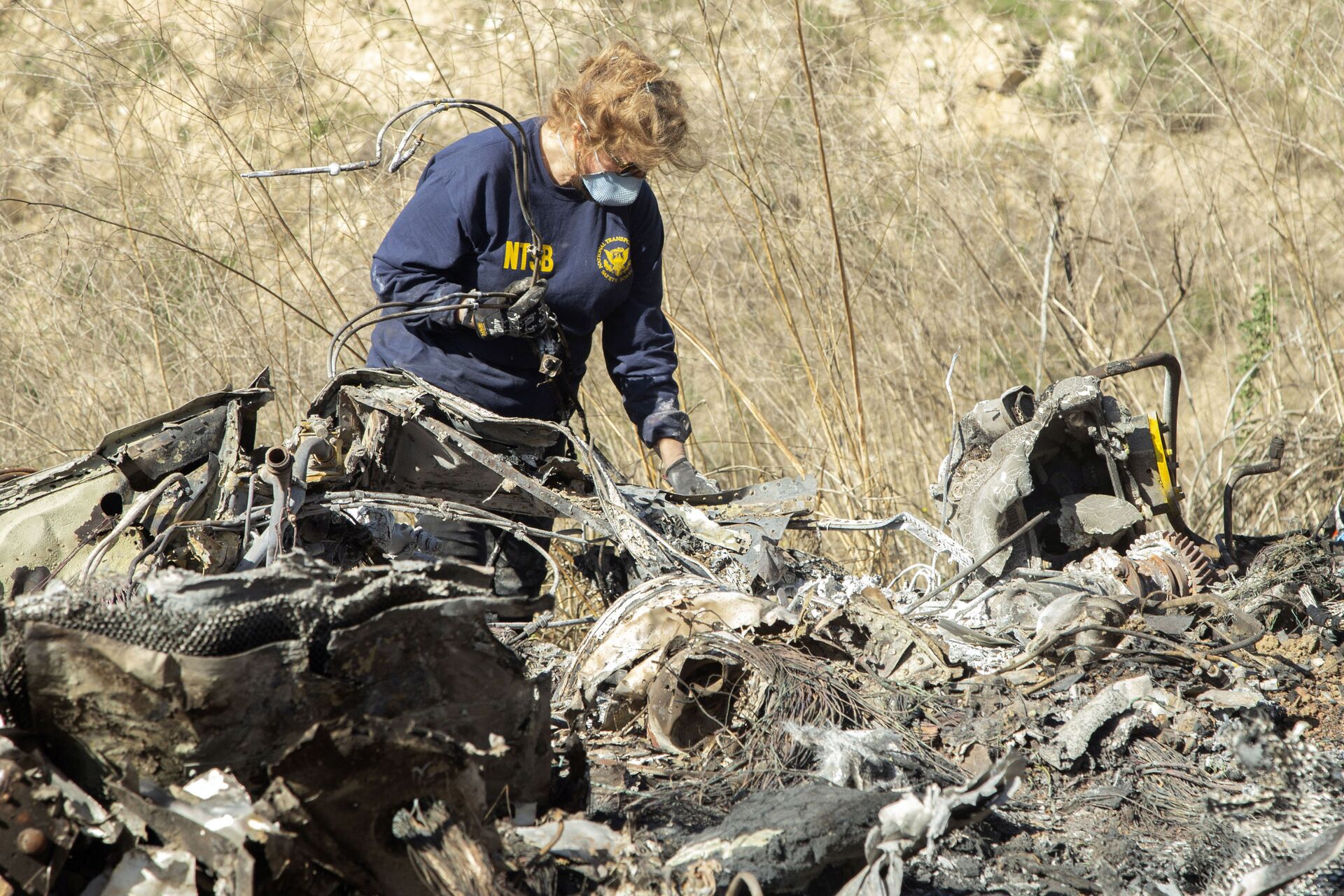 FILE - In this Jan. 27, 2020, file photo, released by the National Transportation Safety Board, NTSB investigator Carol Hogan examines wreckage as part of the NTSB's investigation of a helicopter crash near Calabasas, Calif., that killed former NBA basketball player Kobe Bryant, his 13-year-old daughter, Gianna, and seven others. Federal safety investigators bypassed aviation regulators on Tuesday, June 2, 2020, and urged leading helicopter manufacturers to install so-called black boxes that would help determine the cause of crashes such as the one that killed former NBA star Kobe Bryant. - Sputnik International, 1920, 25.08.2022