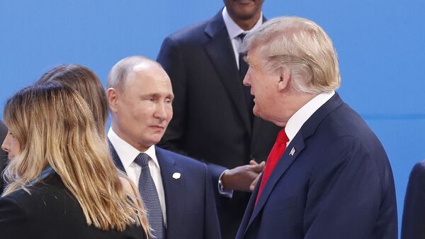 Former US President Donald Trump, right, walks past Russia's President Vladimir Putin, left, as they gather for the group photo at the start of the G20 summit in Buenos Aires, Argentina, in 2018. - Sputnik International