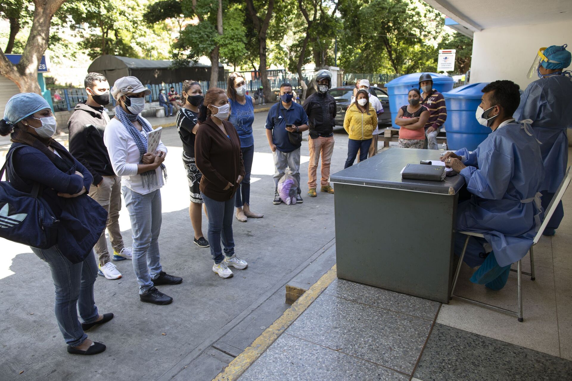 Dr. Wilfredo Sifontes, right, speaks to families who have family hospitalized in the COVID-19 wing, outside José Gregorio Hernández Hospital in the Catia neighborhood of Caracas, Venezuela, Friday, Sept 4, 2020. Sifontes, who oversees the hospital’s emergency services including its coronavirus wing, described having a fever, cough and feeling sick - Sputnik International, 1920, 08.10.2021